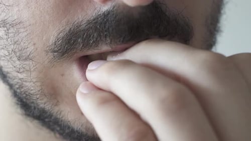 Extreme close up of young man biting his nails