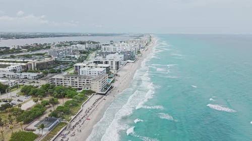 Establishing drone shot of beach and hotels next to Atlantic Ocean with cloudy weather in USA