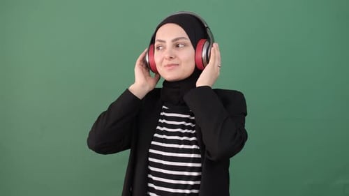 Woman Listening to Music with Headphones on Green Screen