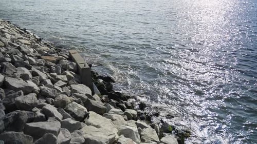 The East River's mighty waves crash against a concrete retaining wall on Brooklyn's jetty.