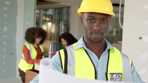 Casual african american male architect looking at plans in office, slow motion, copy space