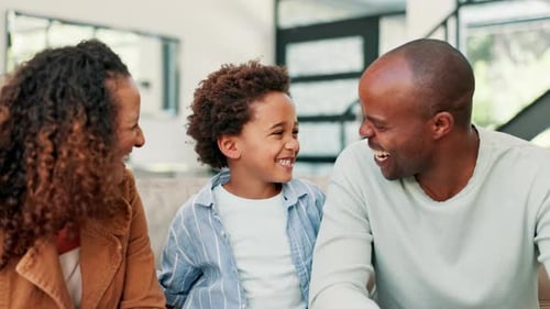 Happy Family Laughing Together Indoors on Couch