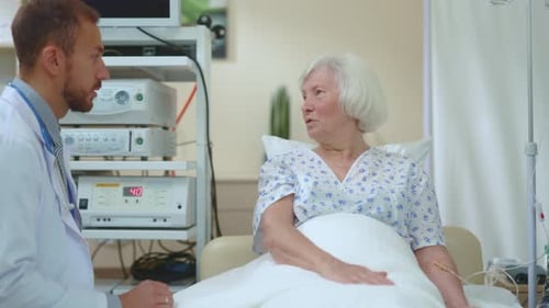 Doctor Examines Senior Woman in Hospital Room
