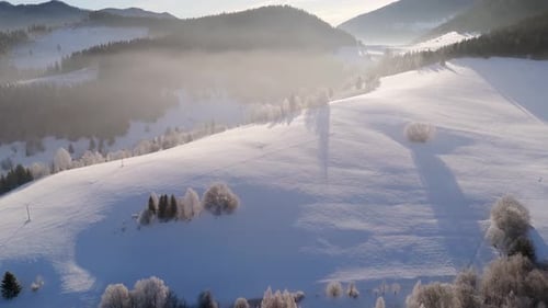 Aerial Scenic Winter Landscape Road Winding Through a Misty Valley Between Snowy Hills