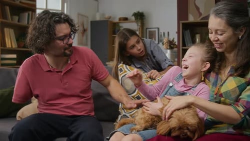Happy Family Petting Dog on Couch at Home