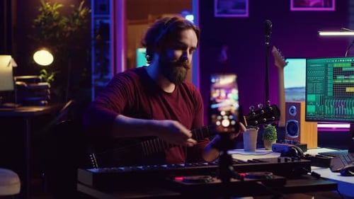 Man Plays Guitar and Keyboard in Home Studio