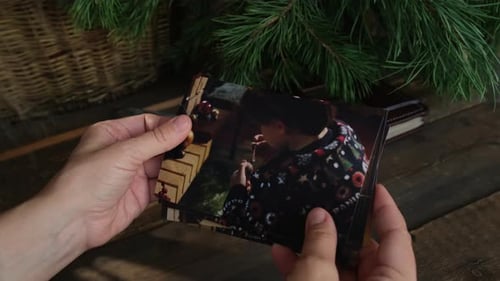 Fotos navideñas impresas a mano hojeando para álbum familiar