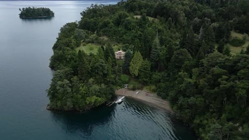 AERIAL. Charming lakeside house on a private island in Chile, featuring a serene dock and scenic