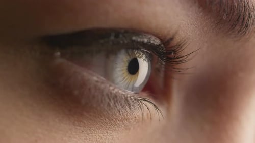 Close-up shot of woman opening her blue eyes and focusing her sight.