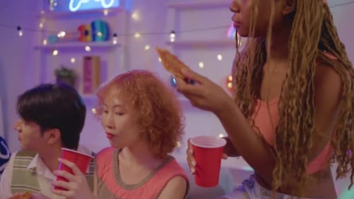 Friends Enjoying Pizza and Drinks at Home Party