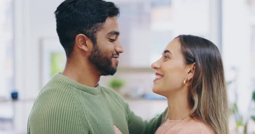 Couple Embraces and Kisses in a Home Setting