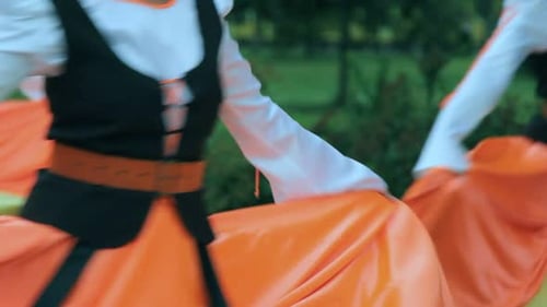 Women in folk costumes dancing in a garden