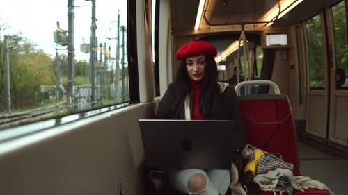 Woman Working on Laptop While Riding Train