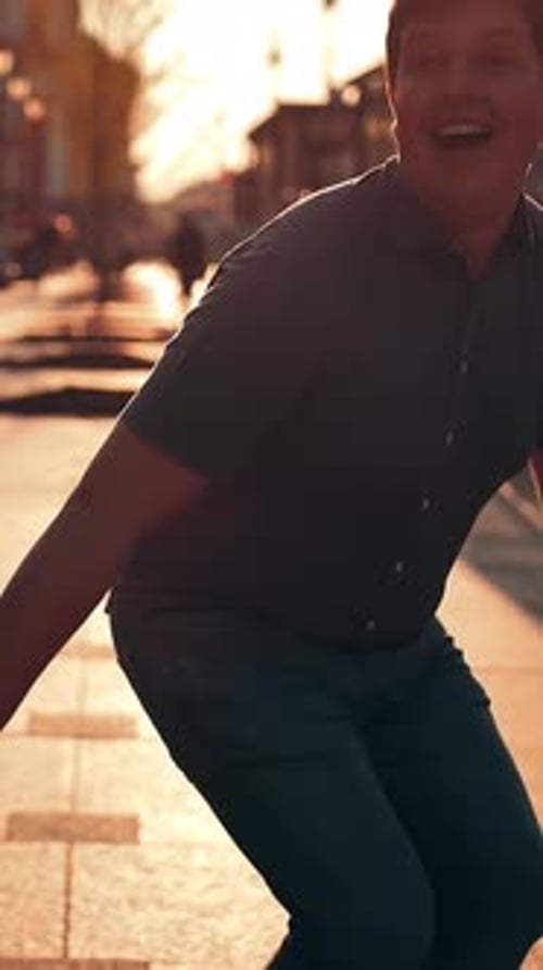 Vertical of Attractive Handsome Young Couple is Jumping Down the Street and Laughing
