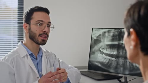Dentist Discussing Dental X-Ray with Patient in Office
