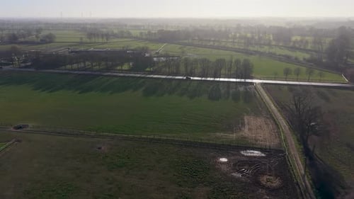 Aerial landscape of green European farmlands at sunrise Long tree shadows stretch across lush fields