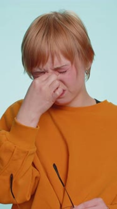 Tired Woman with Eyeglasses Rubbing Eyes Indoors