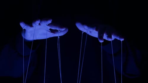 The Puppeteer Controls the Puppets in the Theater in Blue Neon Light Closeup Managing People at Work