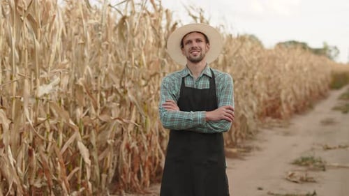 Successful Smiling Male Farmer on Dirt Road Through Field of Corn