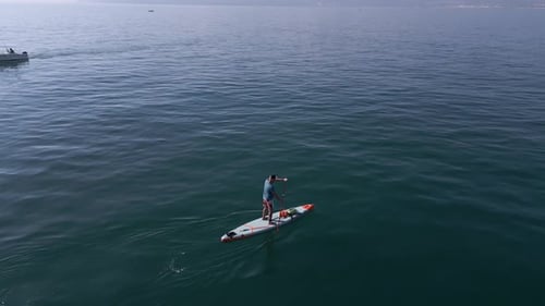 Aerial View of a Man Paddling a Standup Paddleboard or SUP Board on a Calm Sea