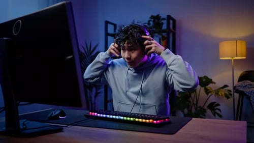 Young Adult Gamer Puts on Headphones