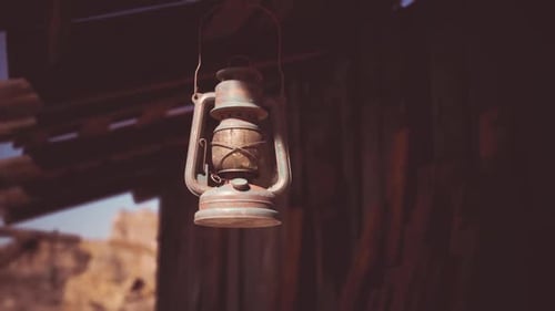 Vintage Rusty Lantern Hanging Under Old Wooden Structure