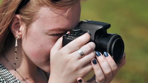 Young Woman Photographer Smiles Taking Pictures Outside