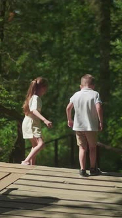 Little Children with Mother Go Downstairs in Green Forest