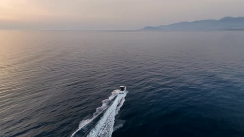 A Bird'seye View of a Small Speedboat in the Bay During Sunset A Picture From a Drone Rushing