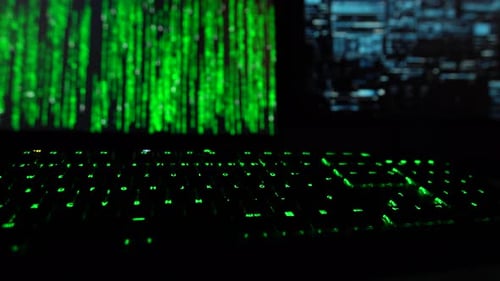 Concept de cybersécurité. Code de piratage sur le changement de couleur sur deux écrans d'ordinateur avec une clé verte clignotante