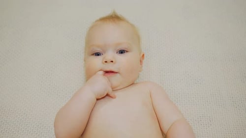 Cool Cute Positive Baby Boy Looks at the Camera Portrait of a Caucasian White Newborn The Face of a