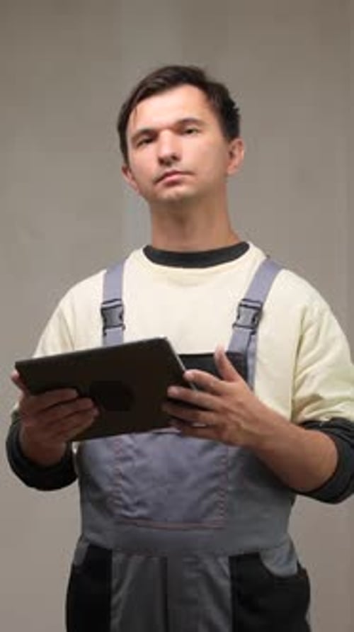 Vertical Video Construction Worker Using Digital Tablet During Home Renovation