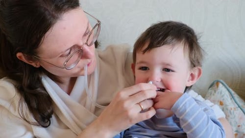 Mother Uses Nasal Aspirator on Young Child