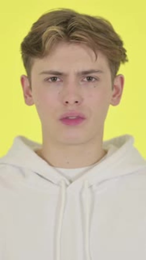 Young Man showing No Sign by Shaking Head on Yellow Background, Vertical Video