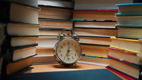 Old Alarm Clock Stands in Stacks of Old Books