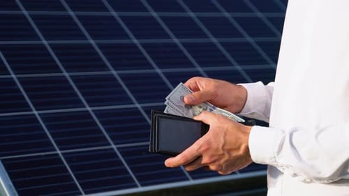Geld sparen mit Sonnenenergie und Sonnenkollektoren Hand in Hand mit Dollar