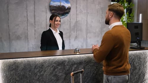 Male Guest Checking in at a Hotel Reception Desk