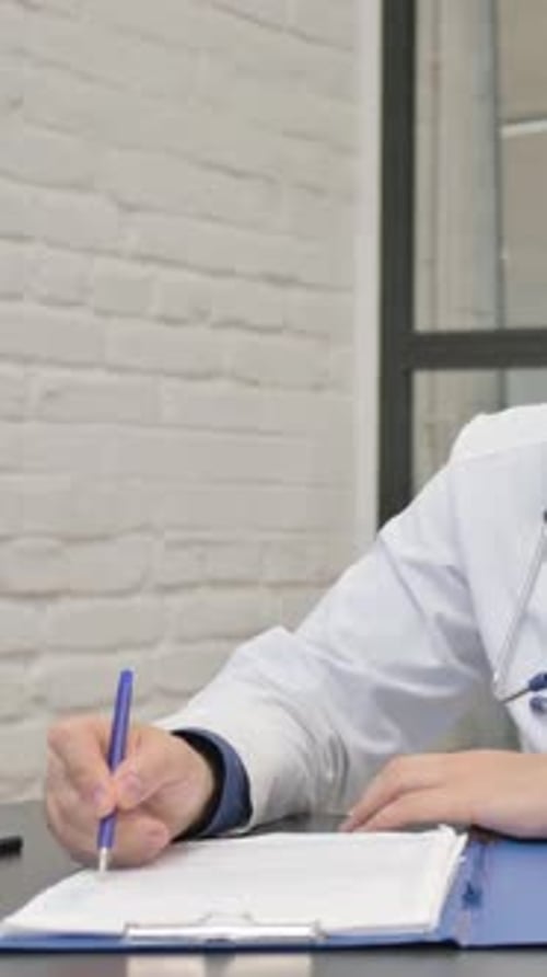 Médecin hispanique travaillant sur des documents en clinique, vidéo verticale