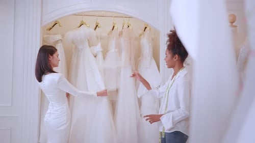 Beautiful bride discussing details with the wedding planner in studio.