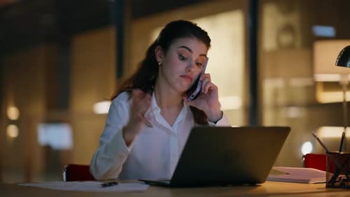 Woman Works Late, Talking on Phone at Laptop