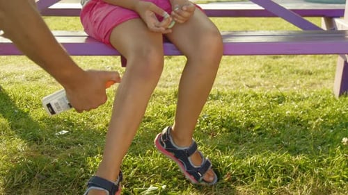 Father Protecting Daughter From Mosquitoes at Sunset Playground