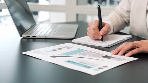 Office Worker Writing Notes Looking at Chart Graph Analysis Statistics