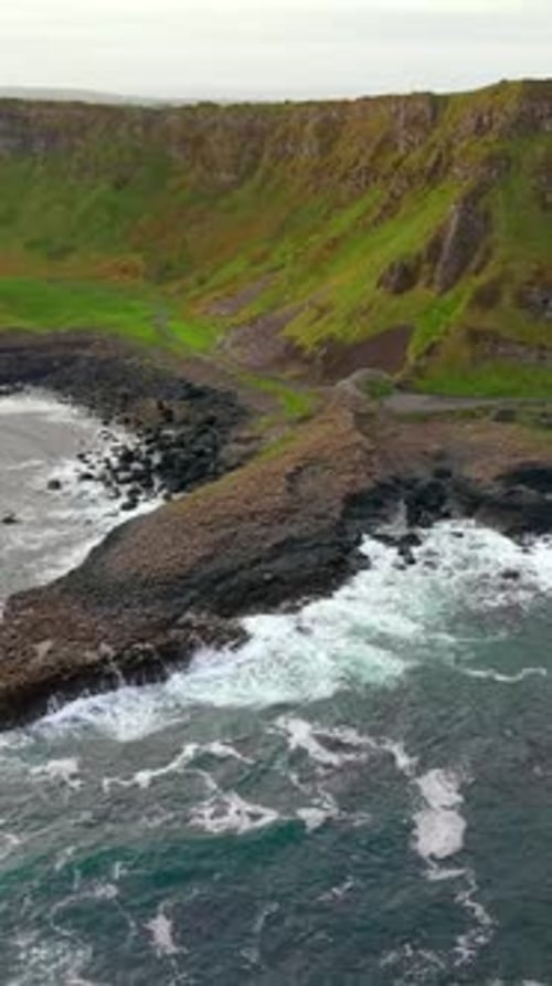 Wide left-to-right social ratio aerial video of The Giant's Causeway in Bushmills, Northern Ireland