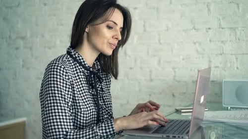 Woman Working on Laptop at Kitchen Counter