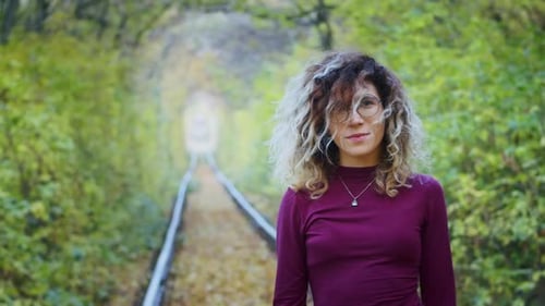 Une jeune touriste heureuse parcourant le tunnel de l'amour avec des feuilles d'automne respirant l'air frais