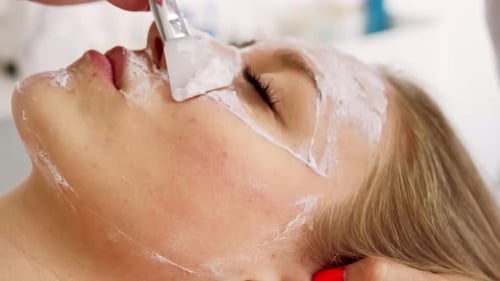 Woman Receiving a Cream Mask Facial Treatment