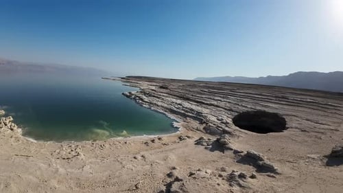 FPV video on the Israeli side of the Dead Sea, with sinkholes and layers of mud in the background