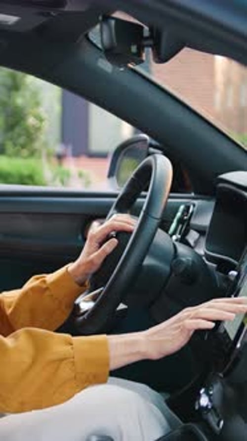 Belle jeune femme configurant la navigation sur un écran à l'intérieur d'une voiture moderne se préparant pour une route