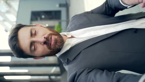 vertical view smartphone camera Caucasian bearded businessman speaks on phone using a front camera