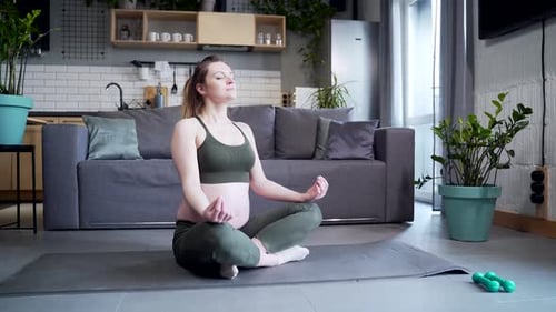 Woman Meditating at Home on Yoga Mat